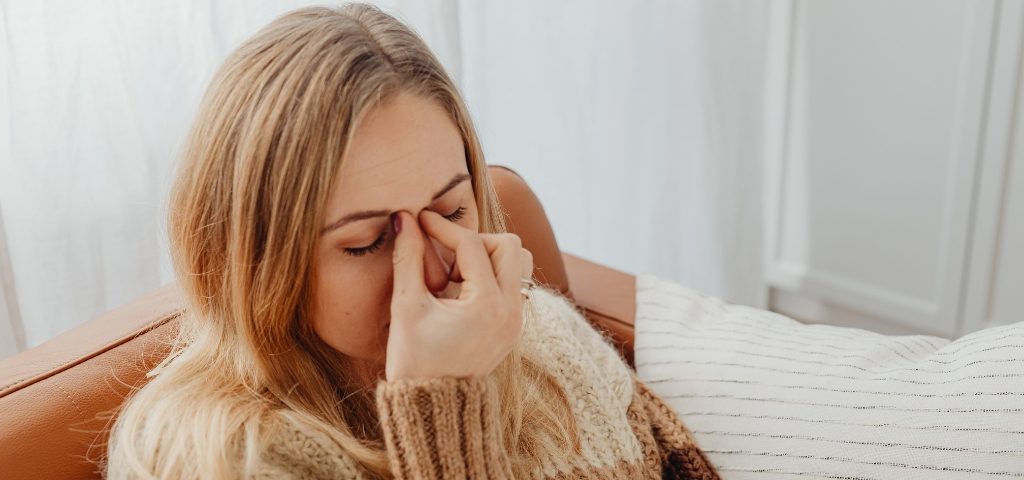 Una mujer que sufre alergias respiratorias dentro de su vivienda.