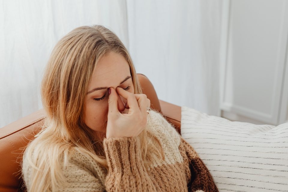 Una mujer que sufre alergias respiratorias dentro de su vivienda.
